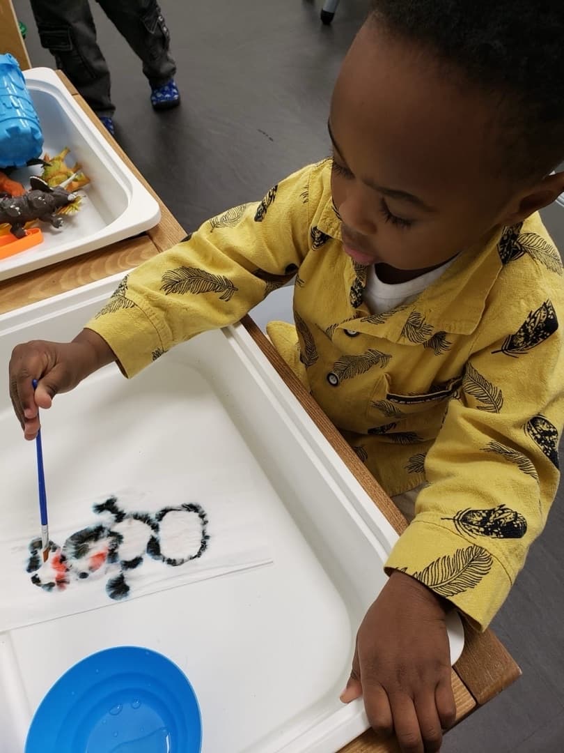 Child exploring sensory paint play