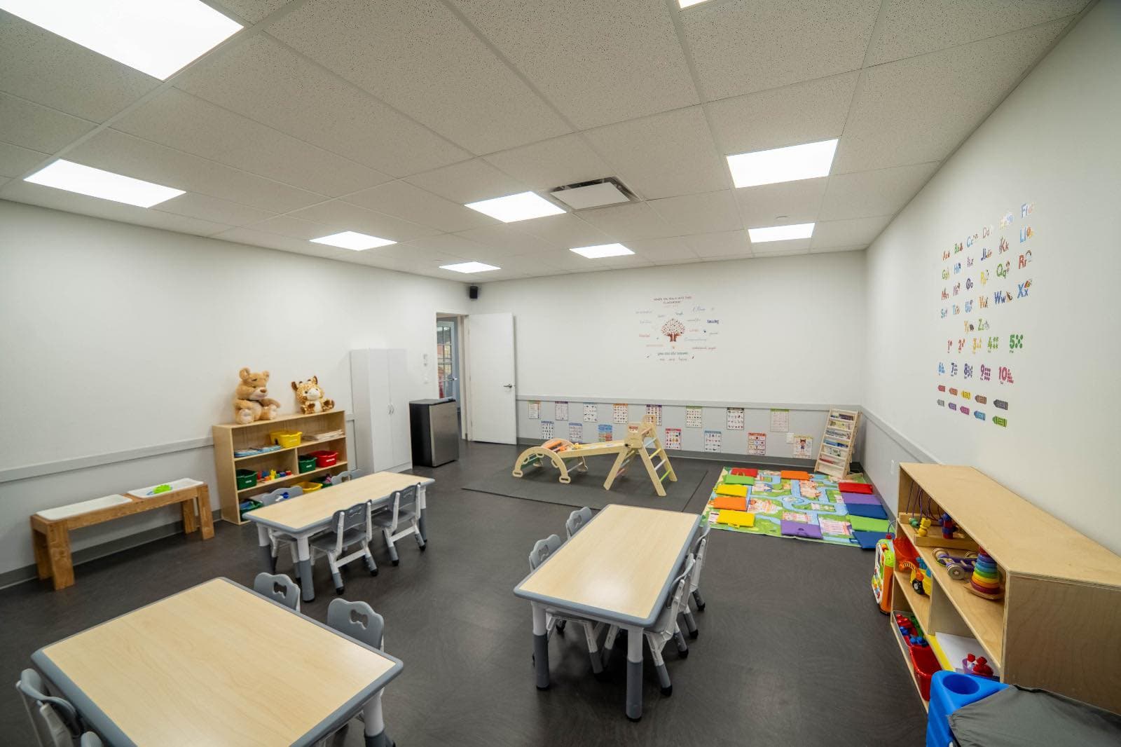 Bright classroom with activity tables and open floor space
