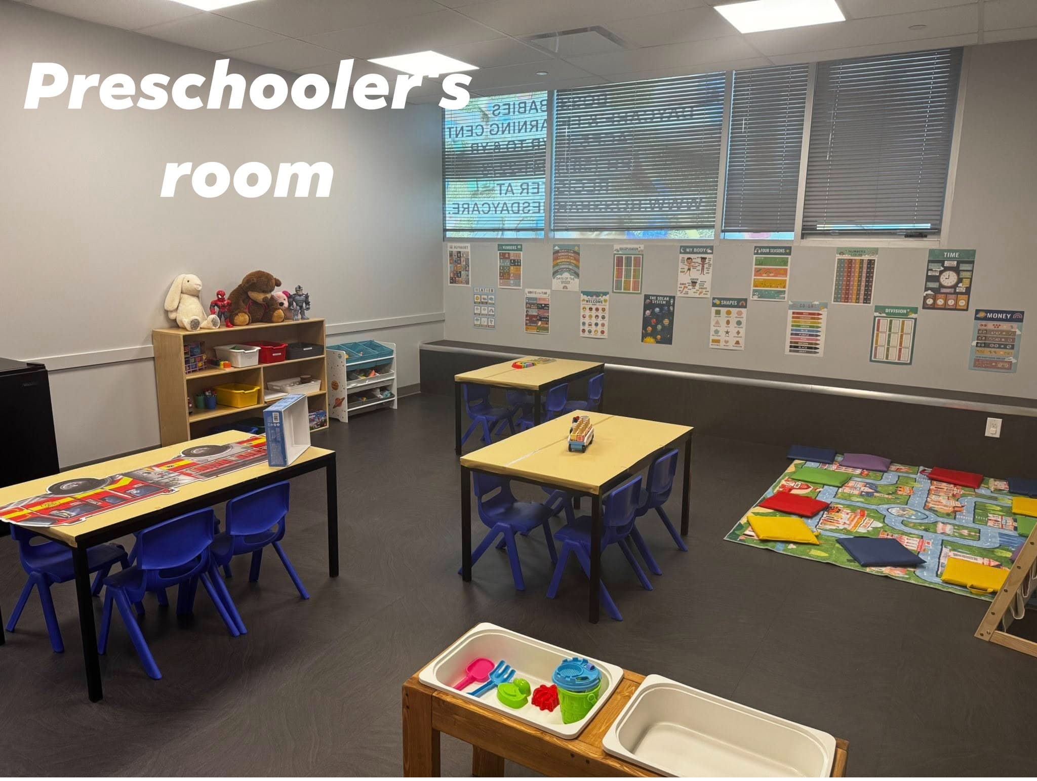 Preschool classroom with tables, learning materials, and open floor space