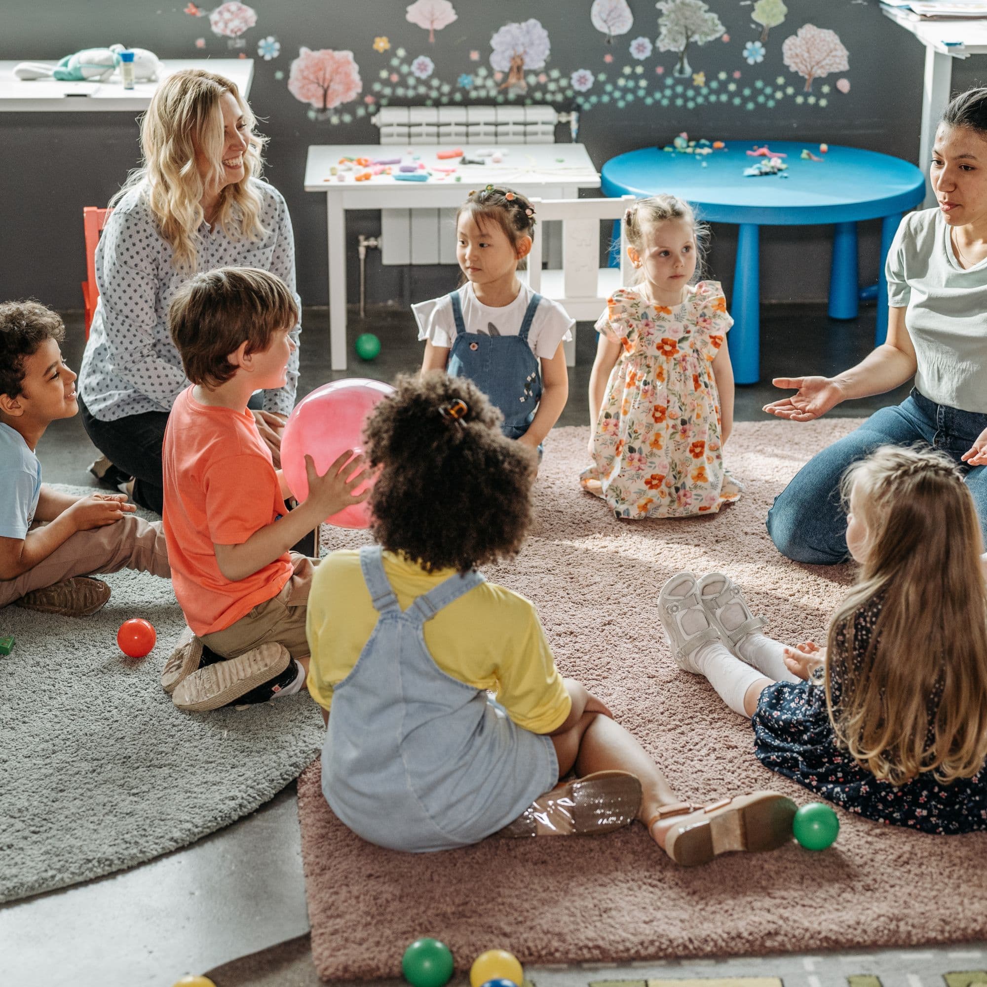 Children playing together with educators in an early learning classroom
